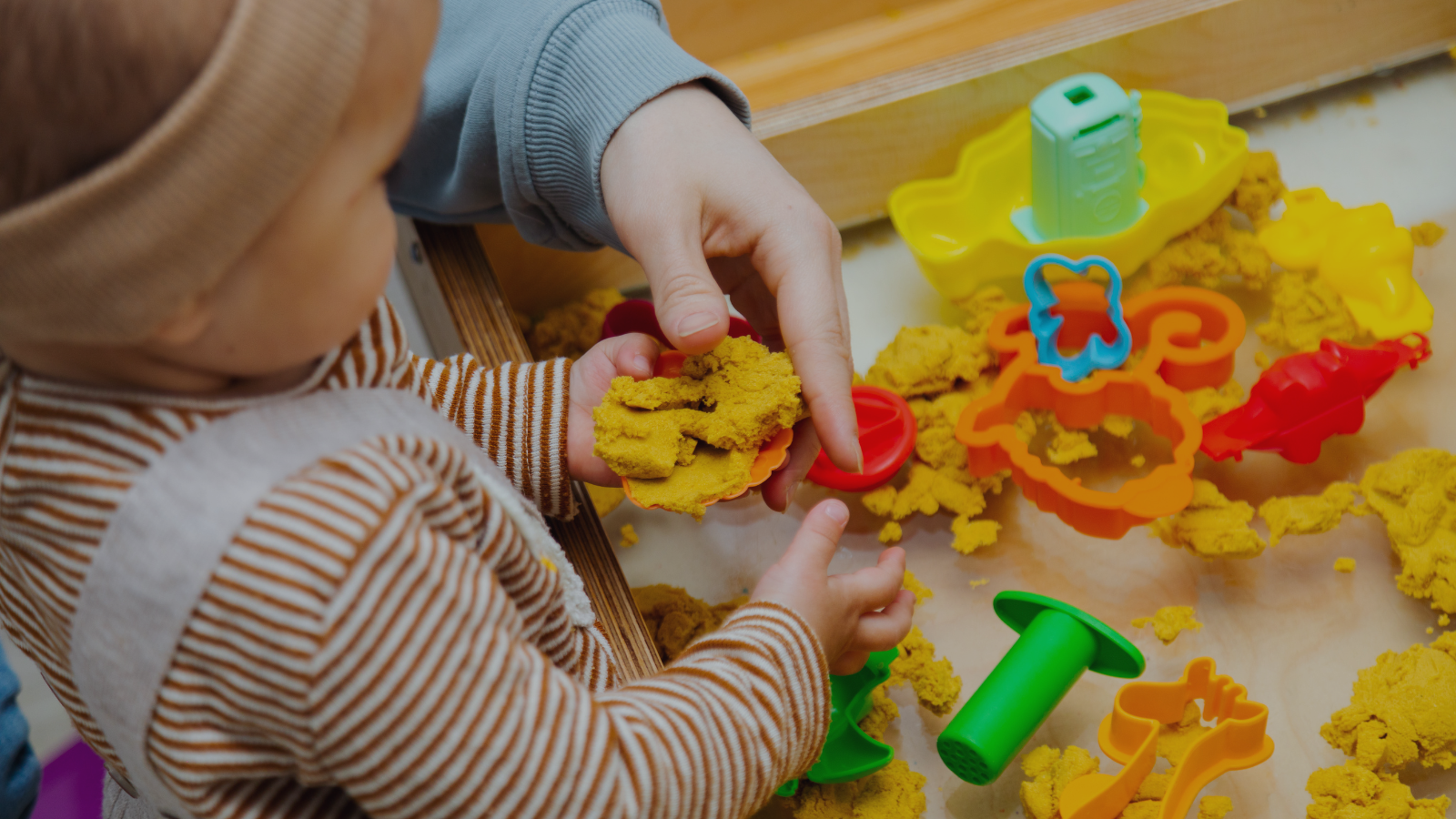 Toddler playing with kinetic sand as a calming sensory activity for overstimulated toddlers after a busy day